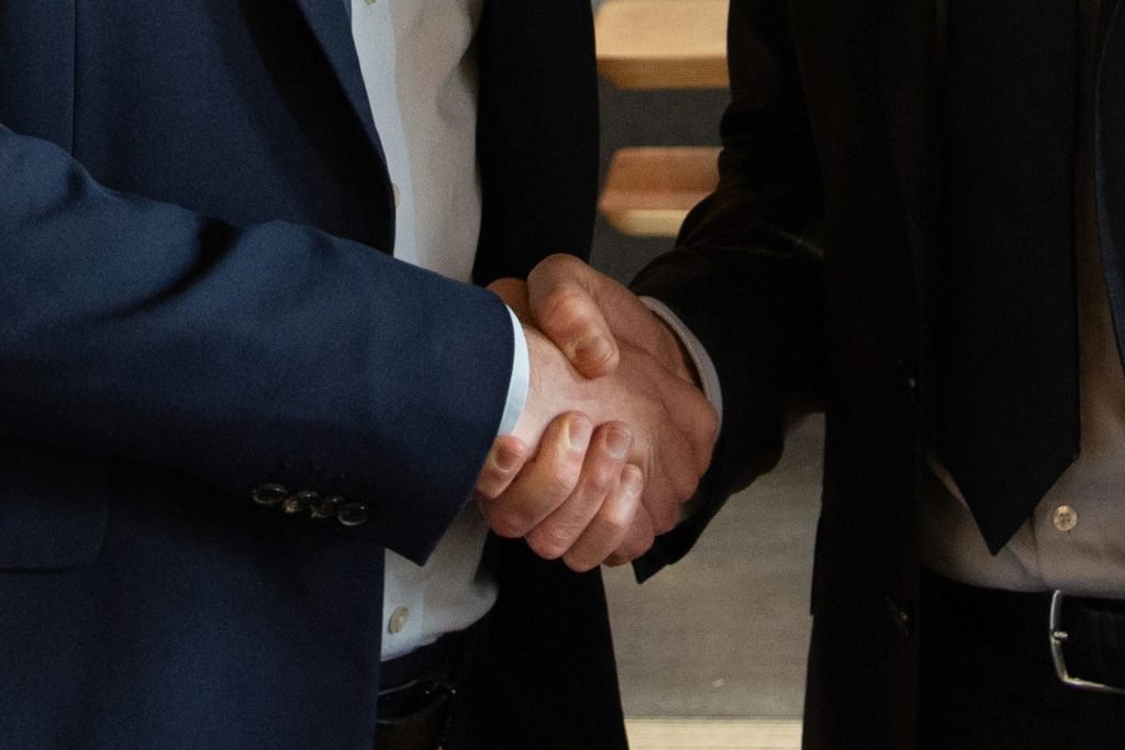 Las socios comerciales se dan la mano, haciendo un trato.