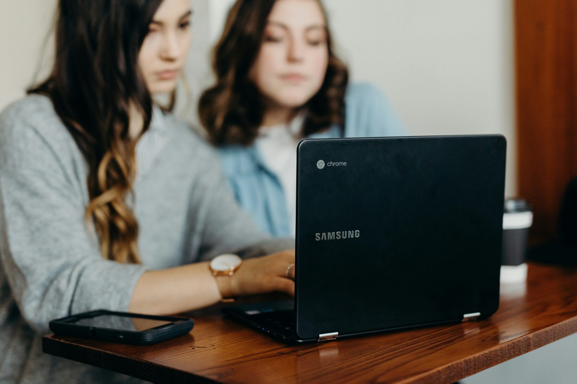 dos mujeres usando una computadora portátil